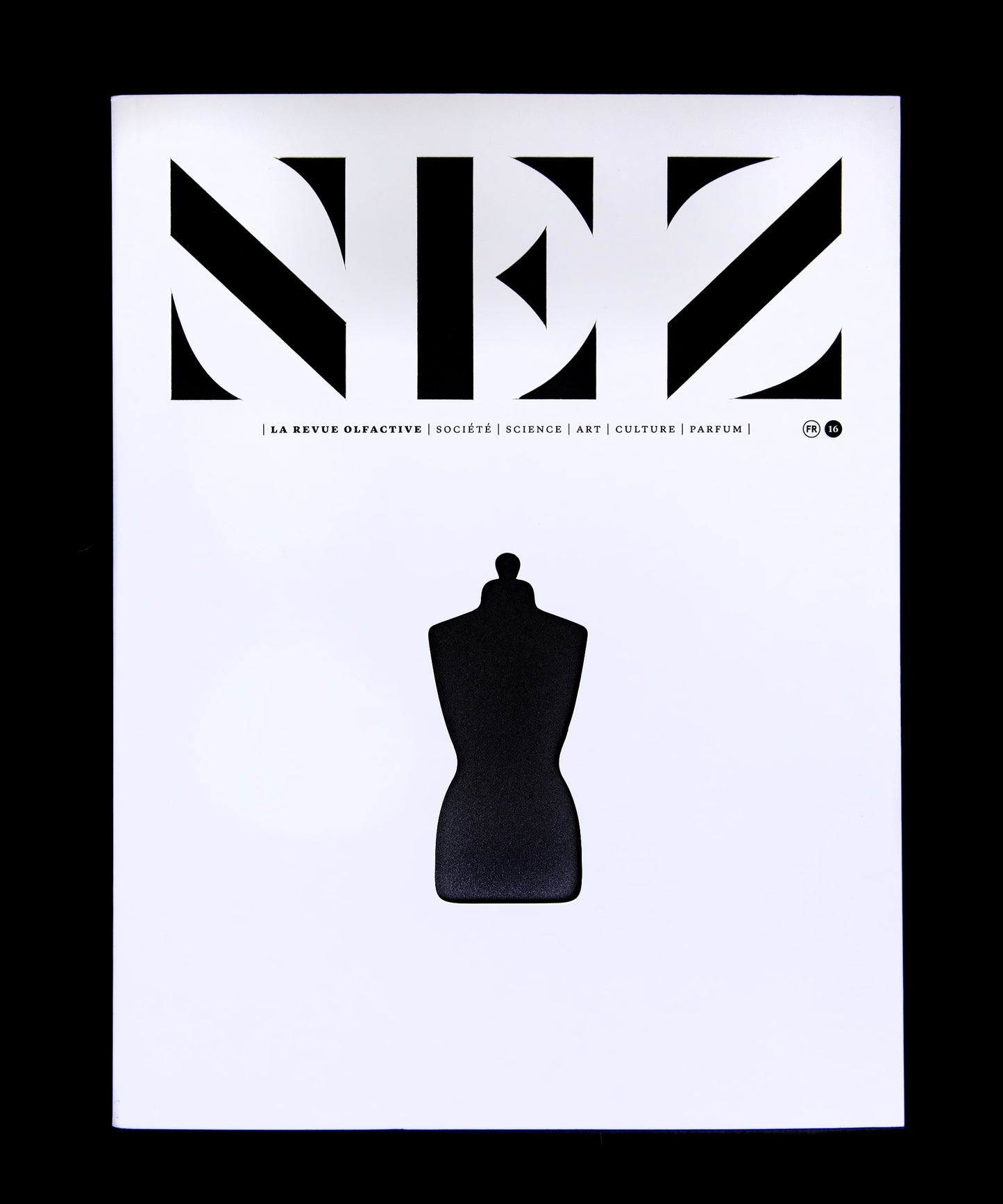 magazine with white cover and black cutouts reading