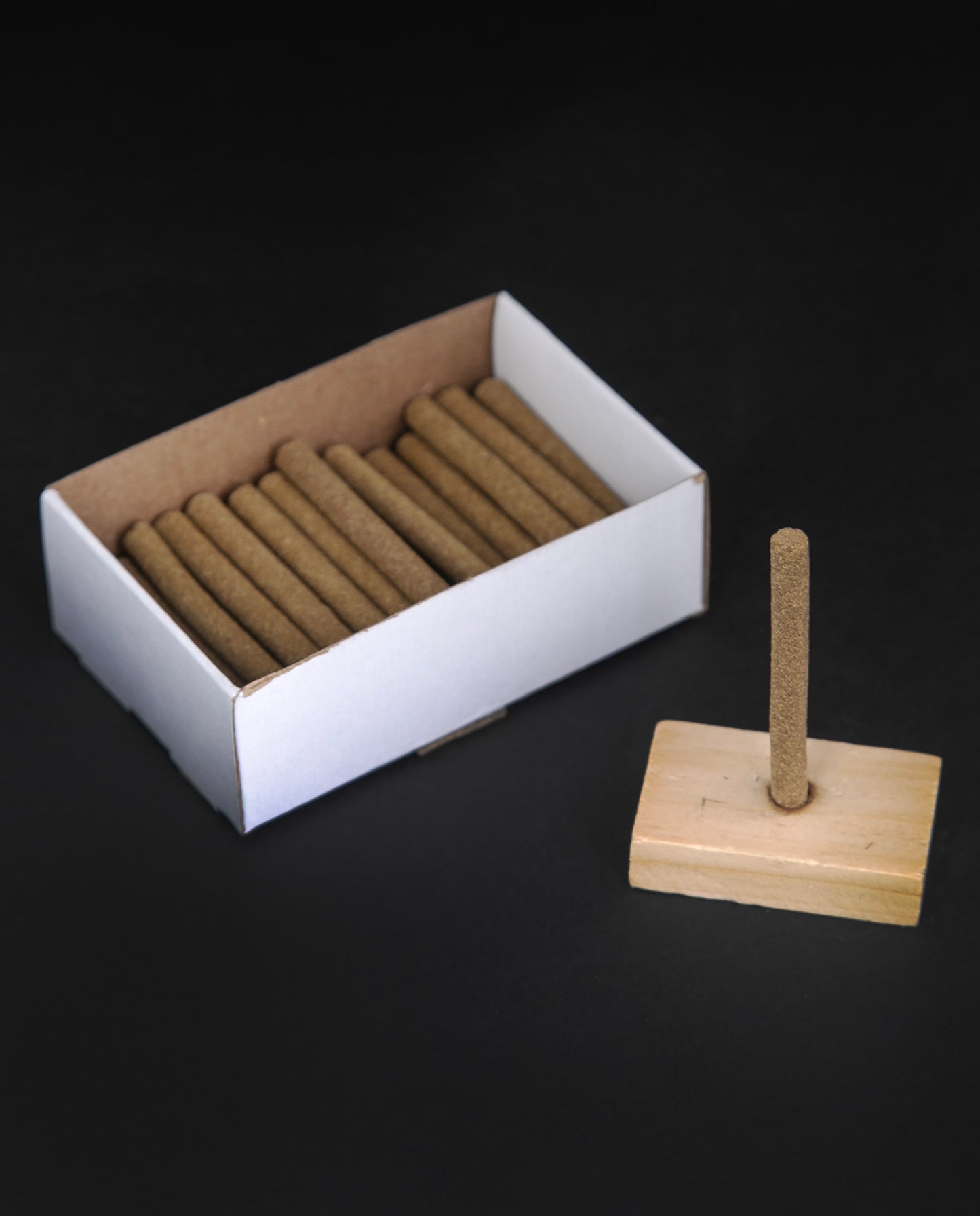 Open box of Paine's Balsam Fir incense logs on black background