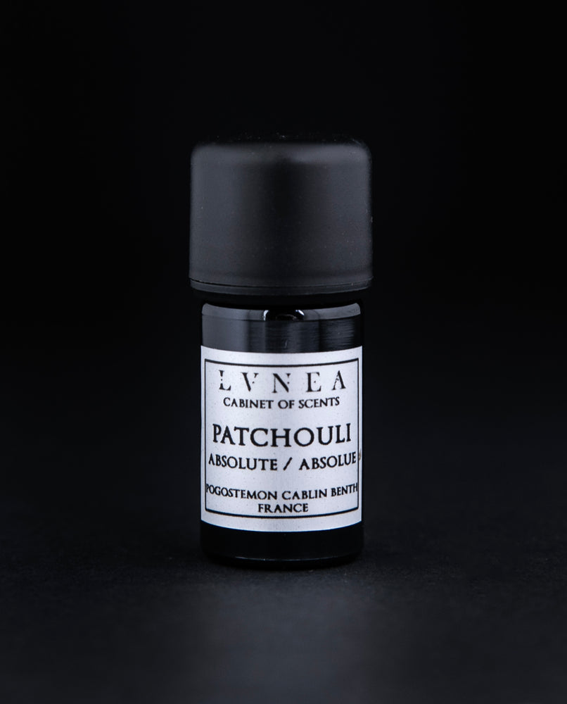 5ml black glass bottle of patchouli absolute on black background