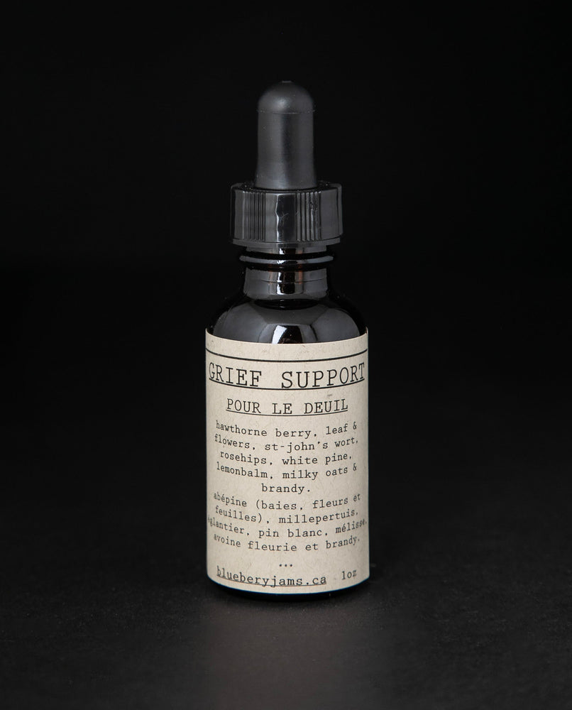 Black glass bottle with dropper top and tan label reading "Grief Support". The bottle contains a herbal tincture by blueberryjams. 