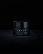 A botanical lip butter made by LVNEA and housed in a black 5g glass pot against a black backdrop. The label reads "LUNE D'ÉPINETTE" on it in silver. 