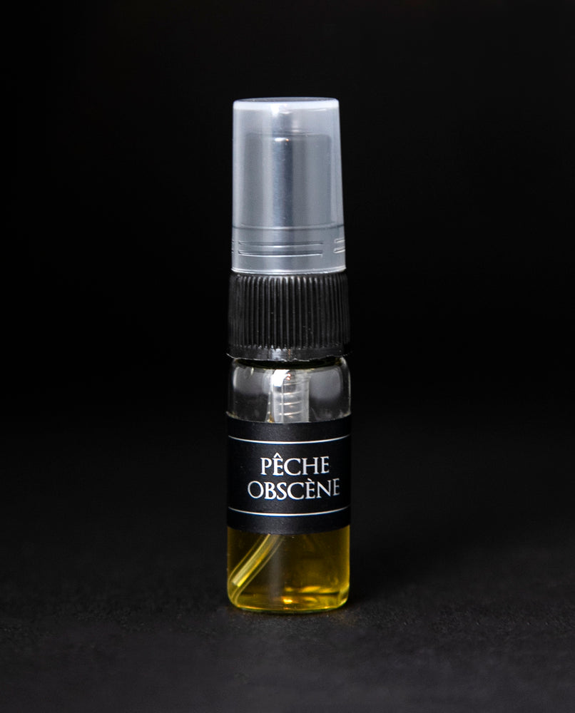 2.5ml glass sample bottle with spray top of LVNEA's Pêche Obscène perfume, on black background