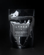 4oz black resealable pouch of LVNEA's Ocean Bathing bath salts standing on black background