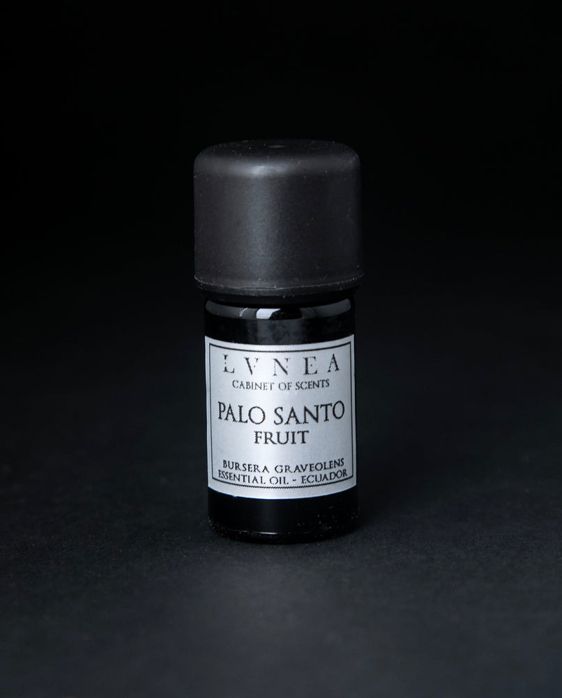 5ml black glass bottle of LVNEA's palo santo fruit essential oil on black background. The label on the bottle is silver.