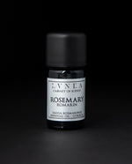 5ml black glass botttle of LVNEA's rosemary essential oil on black background. The label on the bottle is silver.