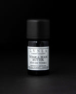 5ml black glass bottle of LVNEA's tonka bean butter on black background. The label on the bottle is silver.