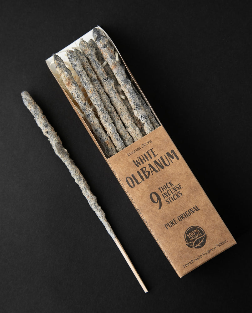 Open box of White Olibanum incense sticks, 1 stick is removed and sitting next to the box.
