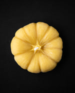 Pumpkin-shaped beeswax candle seen from above.