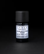 5ml black glass bottle of LVNEA's Alaskan Cypress Wood fractionated essential oil on black background