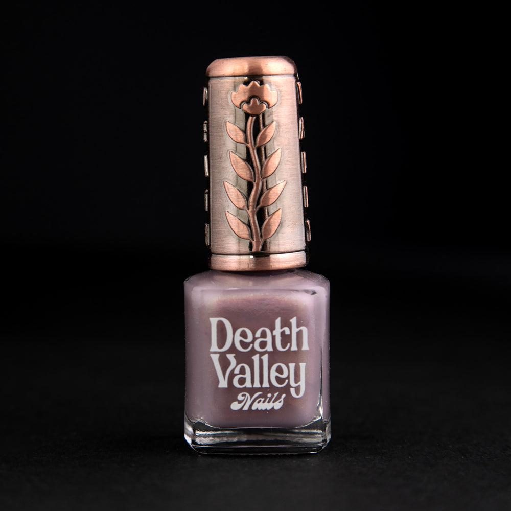
                      
                        "Aliens" nail polish against black background. The polish is a shimmery purple-grey colour.
                      
                    