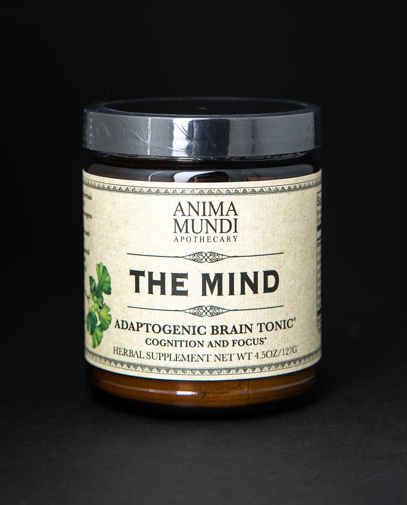 Amber glass jar with black lid of Anima Mundi's "The Mind" herbal supplement. The cream label reads "Adaptogenic brain tonic"