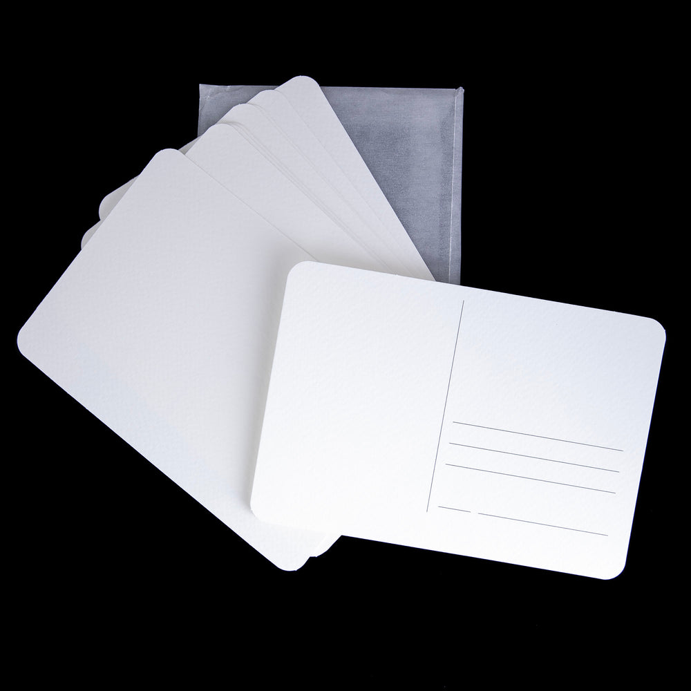 a set of 12 blank white postcards against a black background