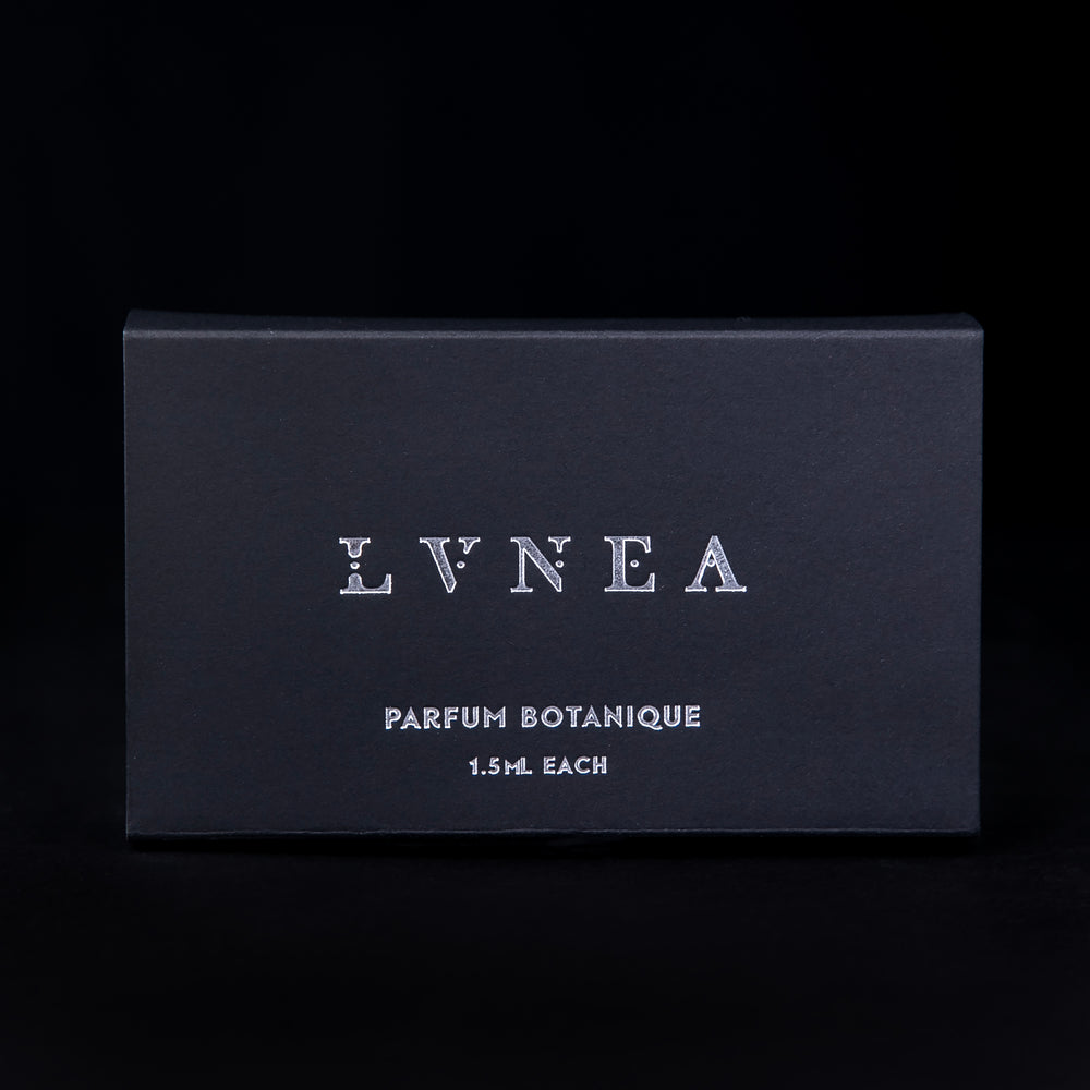 
                      
                        Packaging for the full parfum botanique sample set seen from the front against a black background. The box is black, with LVNEA's logo embossed in silver
                      
                    