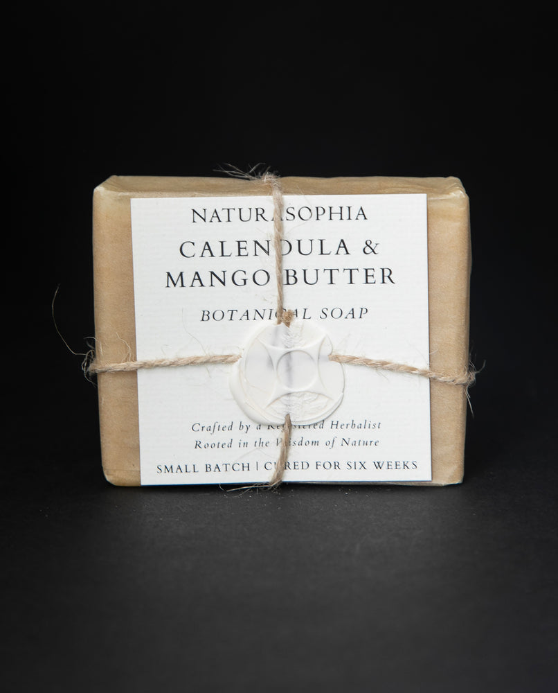 Bar of Naturasophia soap wrapped in brown paper and twine, with a label that reads "Calendula & Mango Butter". There is a white wax stamp holding the label in place.