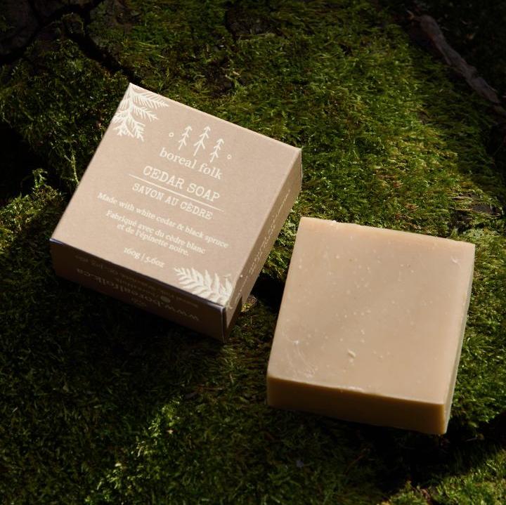 Bar and box of cedar soap laid atop a bed of moss