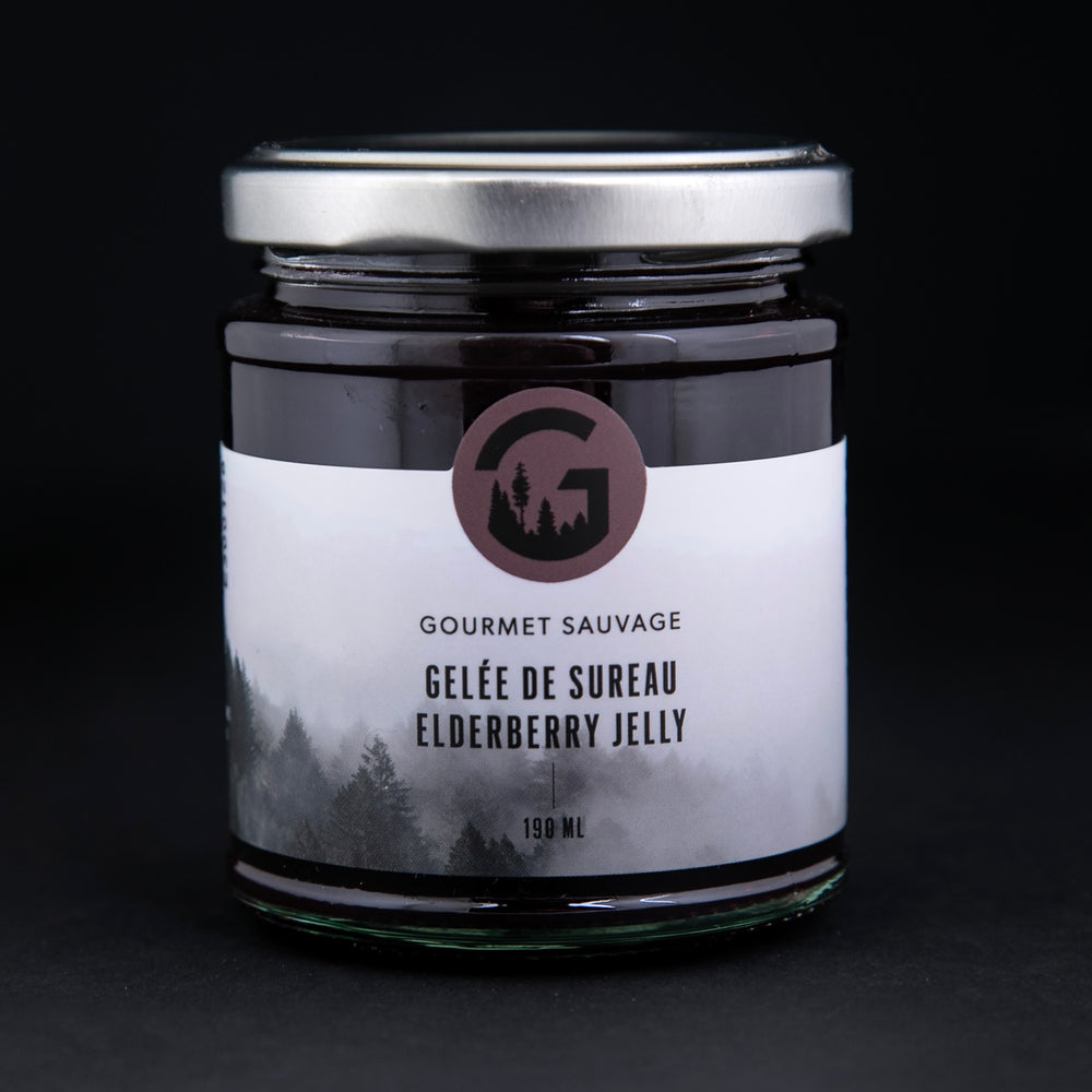 elderberry jelly in a clear glass jar against a black background