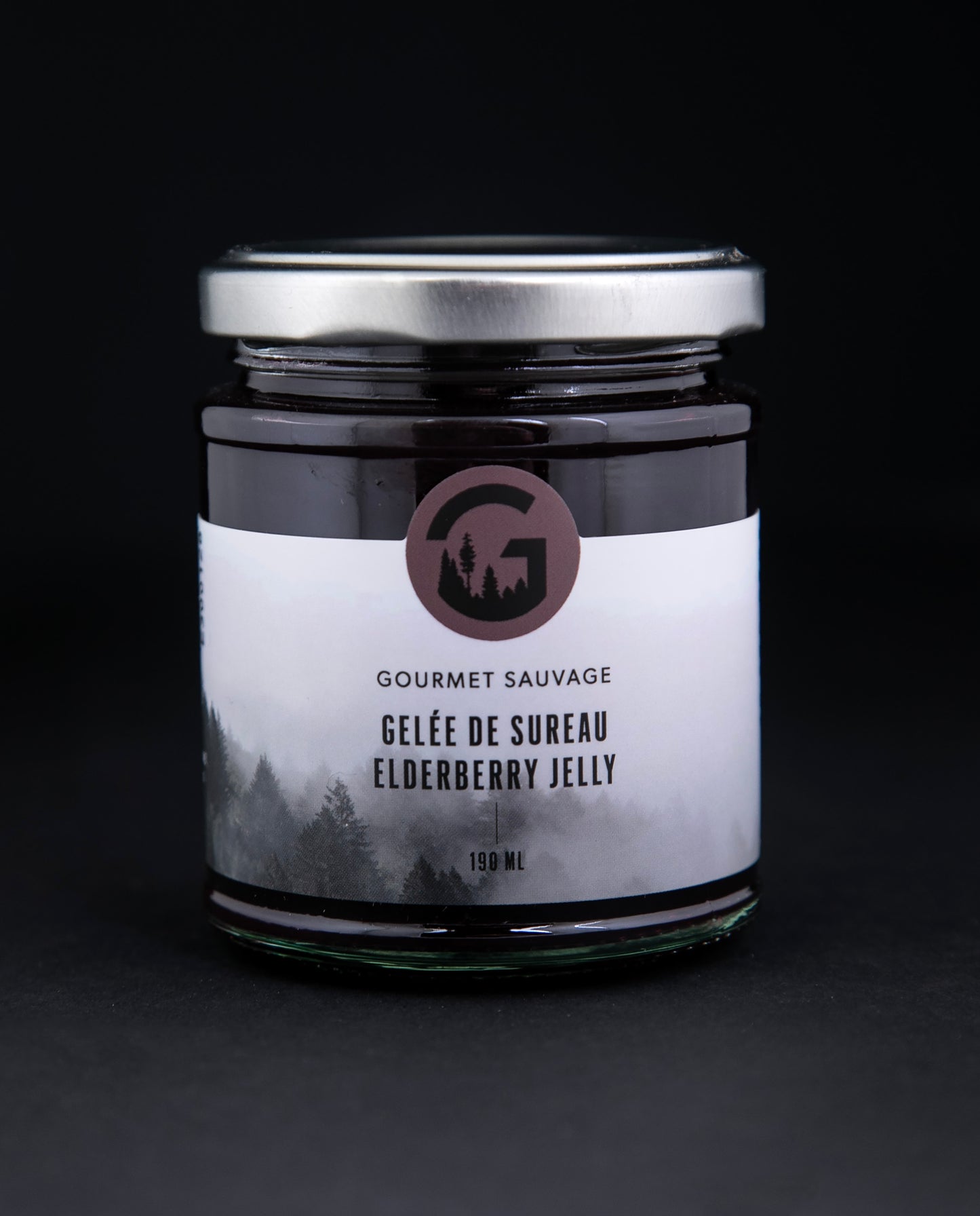elderberry jelly in a clear glass jar against a black background
