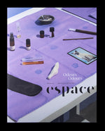 Front cover of Espace magazine's "Odours" issue. Pictured is a minimalist tablescape of vials and curiosities on a purple tablecloth,