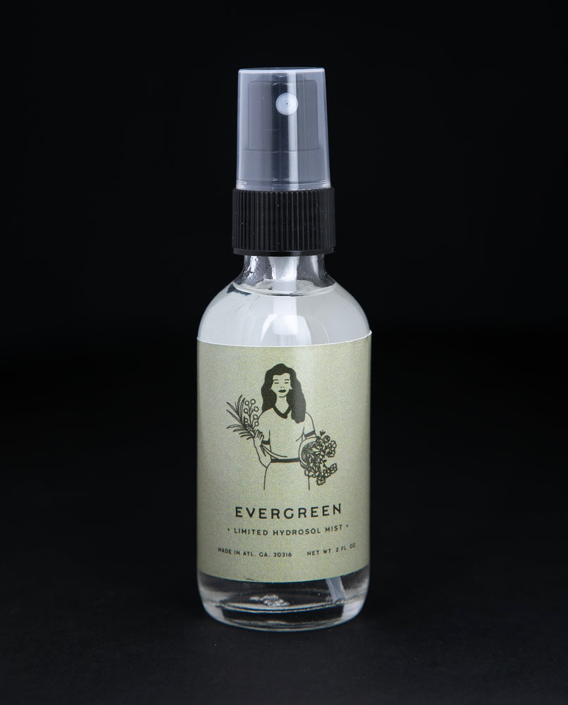 2oz clear glass bottle of Rowan & Sage's "Evergreen" hydrosol. The label on the bottle is light sage green.