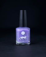 "Gris-Gris of the Bog" nail polish by Death Valley Nails on black background. The polish colour is lilac purple with silvery flecks.