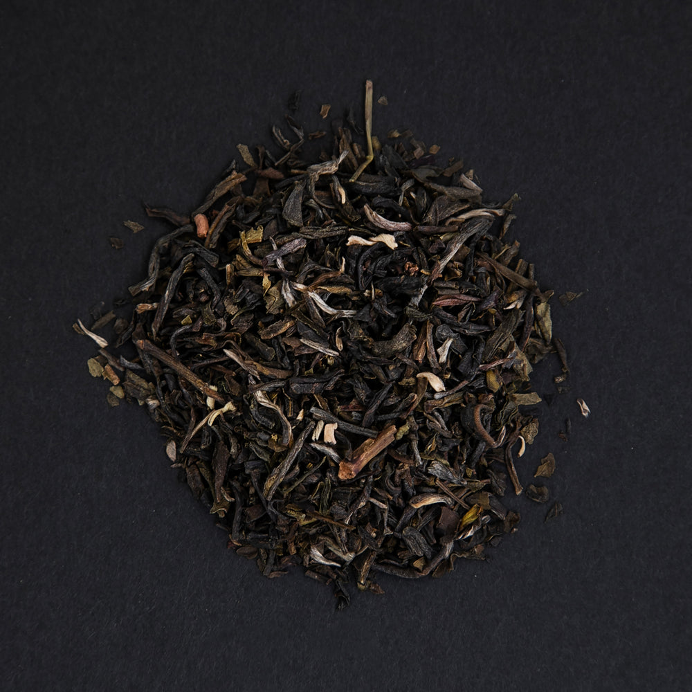 small pile of "jasmin mandarin" tea viewed from above against a black background