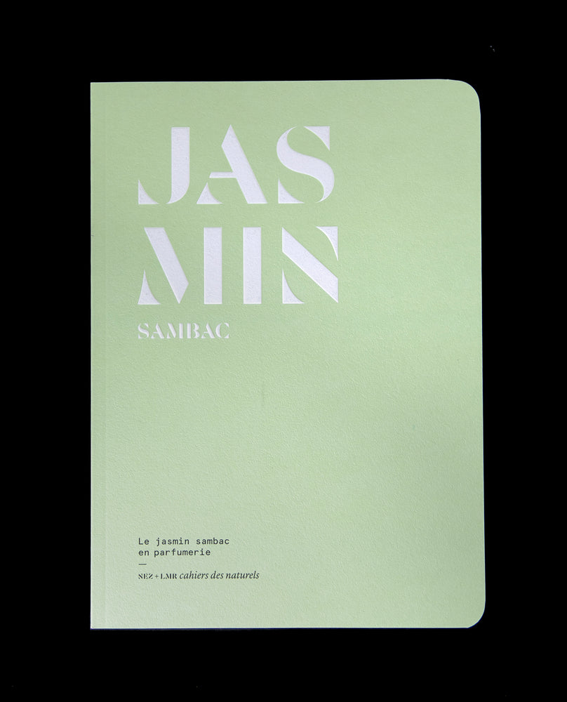 The book "Le jasmin sambac en parfumerie" against a black background. The book is pale green, with the word "JASMIN" written on the cover in bold graphic white lettering