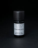 5ml black glass bottle of LVNEA's magnolia essential oil on black background. The label on the bottle is silver.