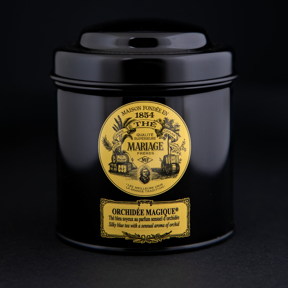 100g black laquered metal canister of Mariage Frère's "Orchidée Magique" tea blend on black background.