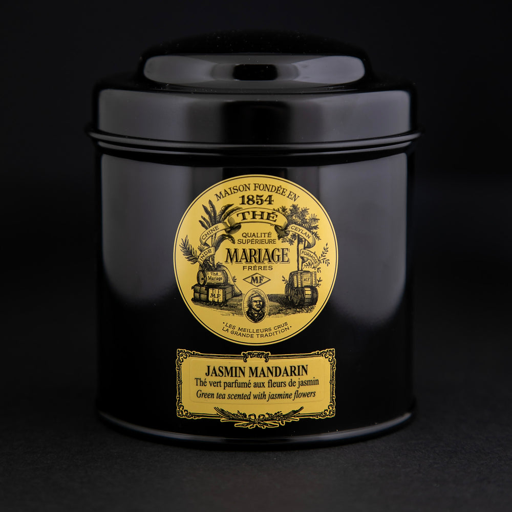 100g black laquered metal canister of Mariage Frère's "Jasmin Mandarin" tea blend on black background.