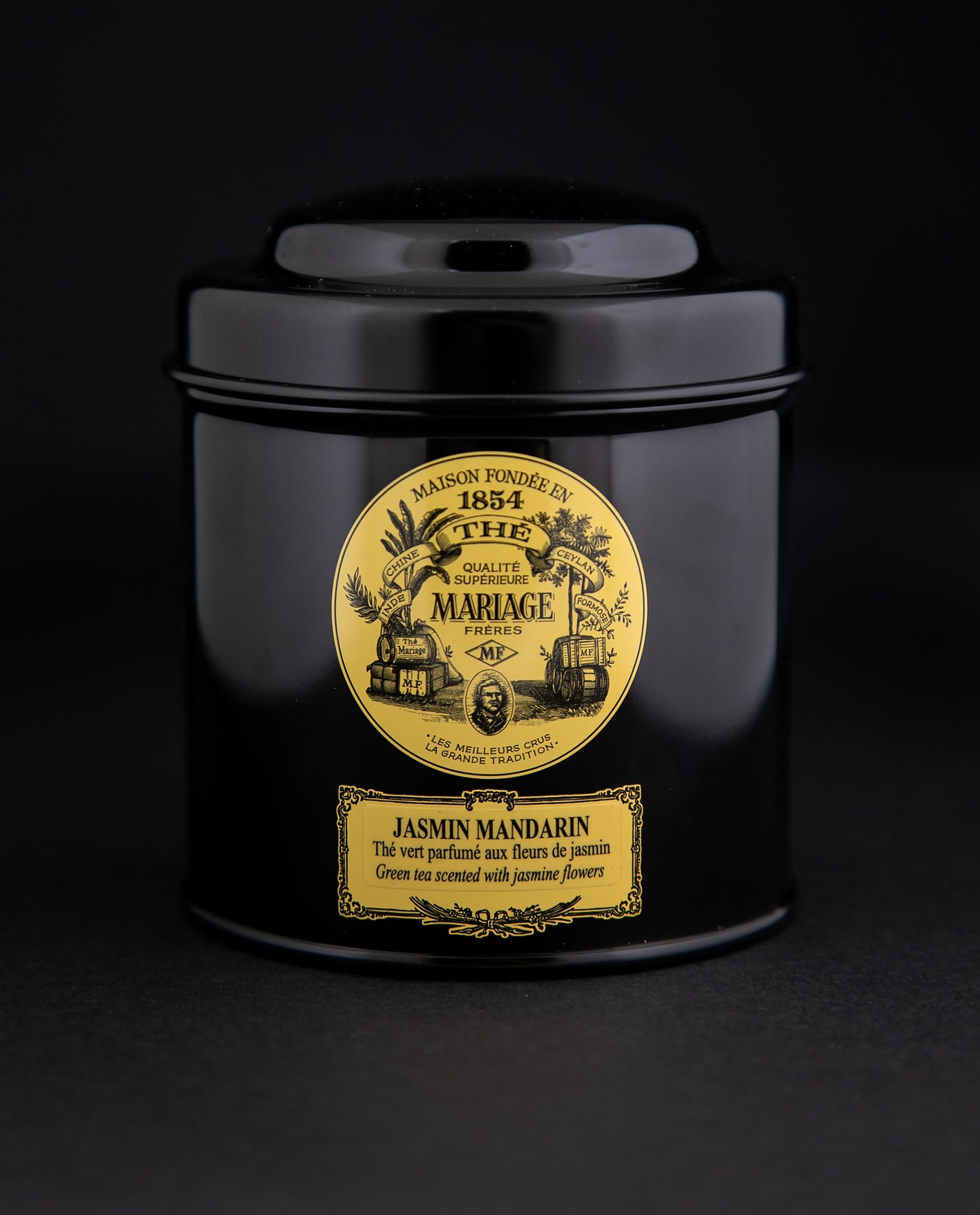 100g black laquered metal canister of Mariage Frère's "Jasmin Mandarin" tea blend on black background.