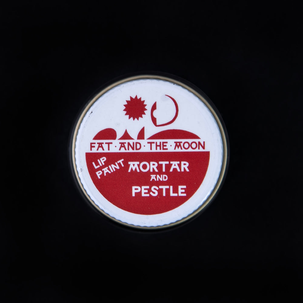 
                      
                        Closed glass pot of Fat and the Moon "Mortar & Pestle" lip paint seen from above on black background.
                      
                    