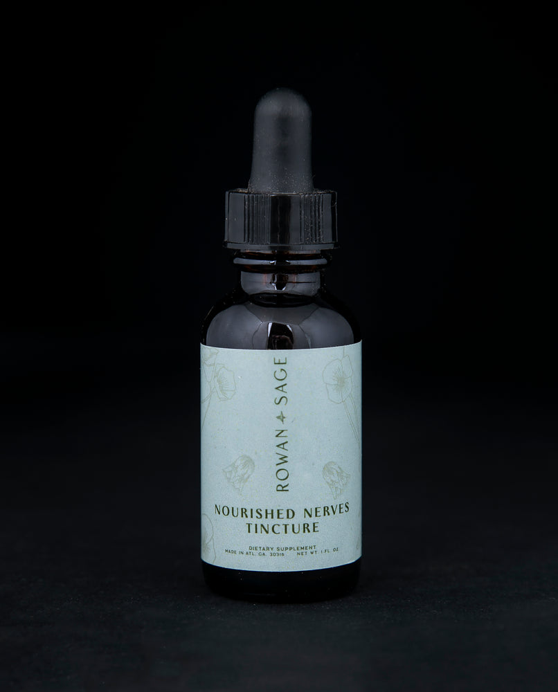 1oz amber glass bottle with dropper top and light blue label, containing Rown + Sage's "Nourished Nerves" tincture on black background.