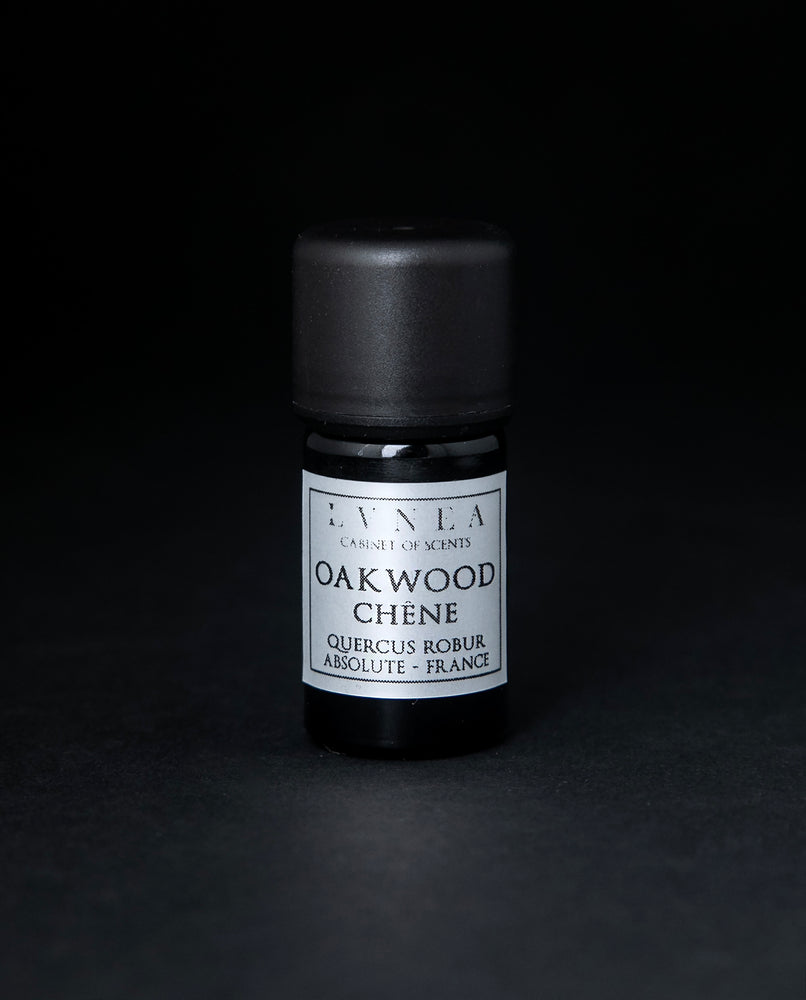 5ml black glass bottle of LVNEA's oakwood absolute on black background. The label on the bottle is silver.