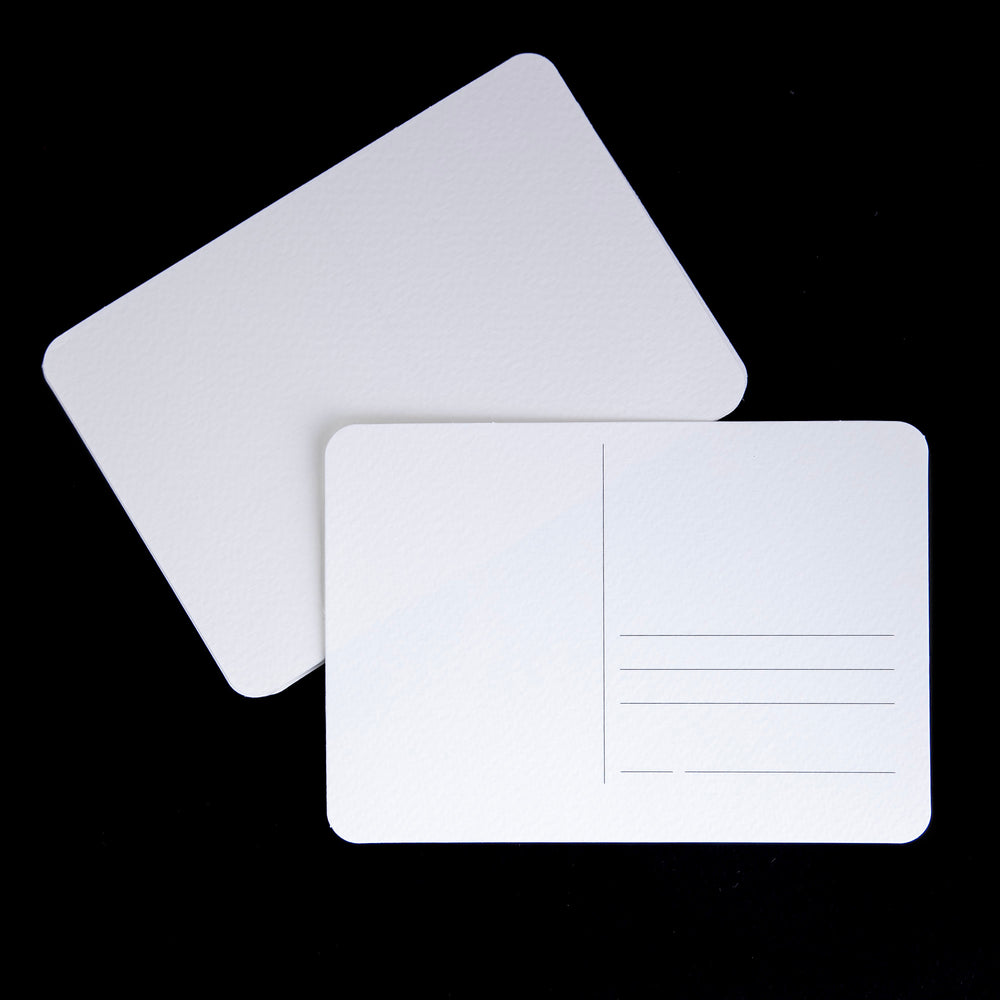 two blank white postcards against a black background