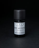 5ml black glass bottle of LVNEA's red myrtle essential oil on black background. The label on the bottle is silver.