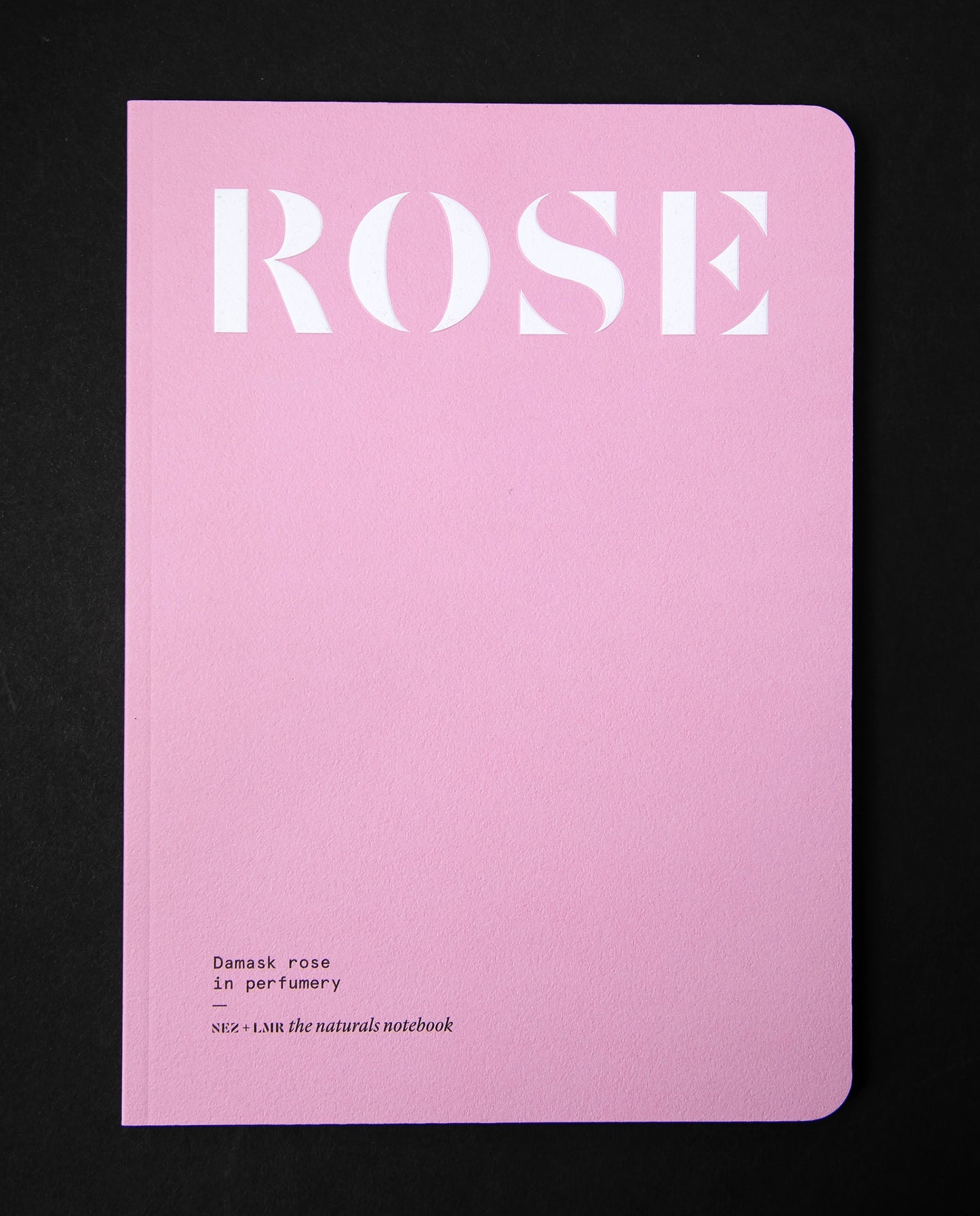 "Damask Rose in Perfumery" book on black background. The cover is flat pink and reads "ROSE" in a big bold font.