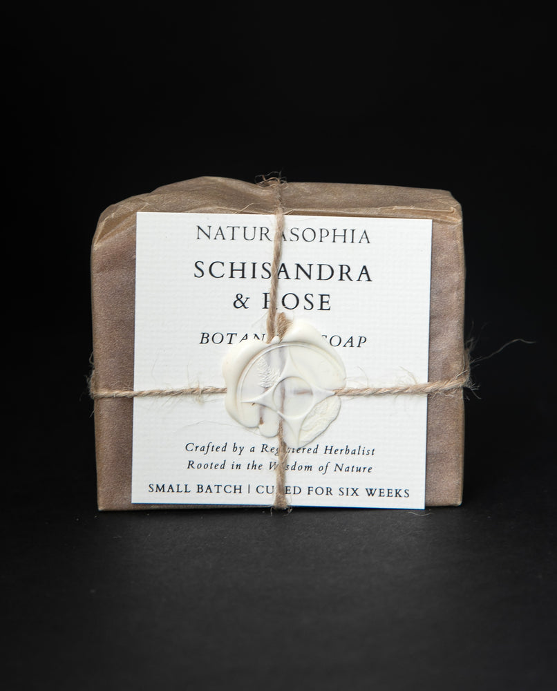 Bar of Naturasophia soap wrapped in brown paper and twine, with a label that reads "Schisandra & Rose". There is a white wax stamp holding the label in place.