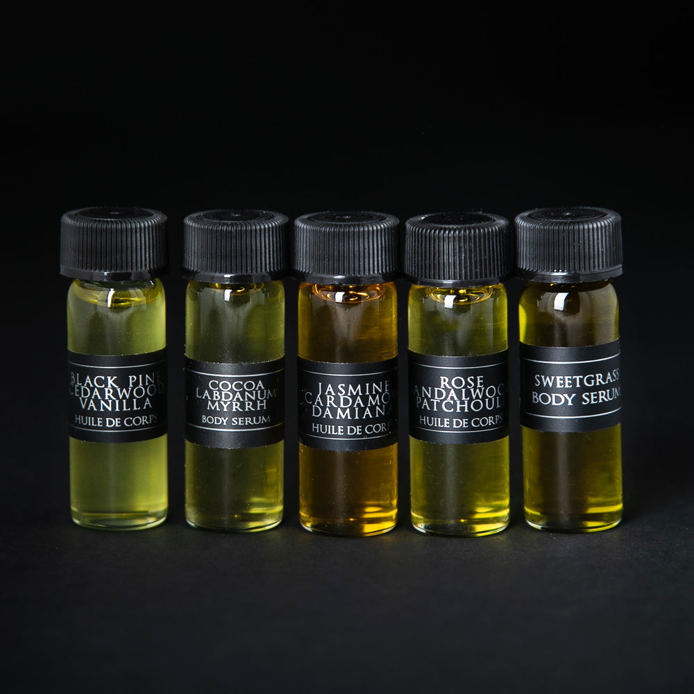 4ml glass sample vials of each of LVNEA's five body serums. They are lined up next to each other on a black background