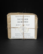 Bar of Naturasophia soap wrapped in brown paper and twine, with a label that reads "Sicilian Almond". There is a white wax stamp holding the label in place.