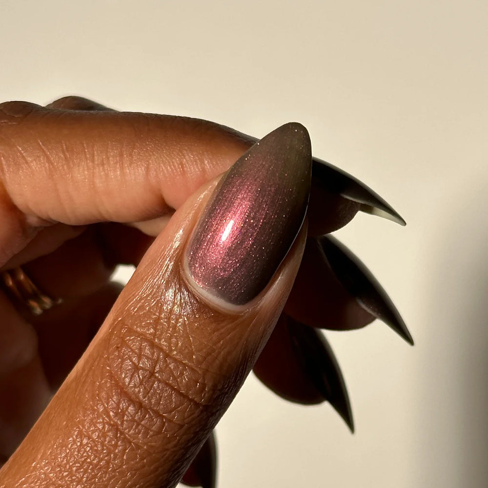
                      
                        Close-up of a hand with a metallic pink copperish nail polish
                      
                    