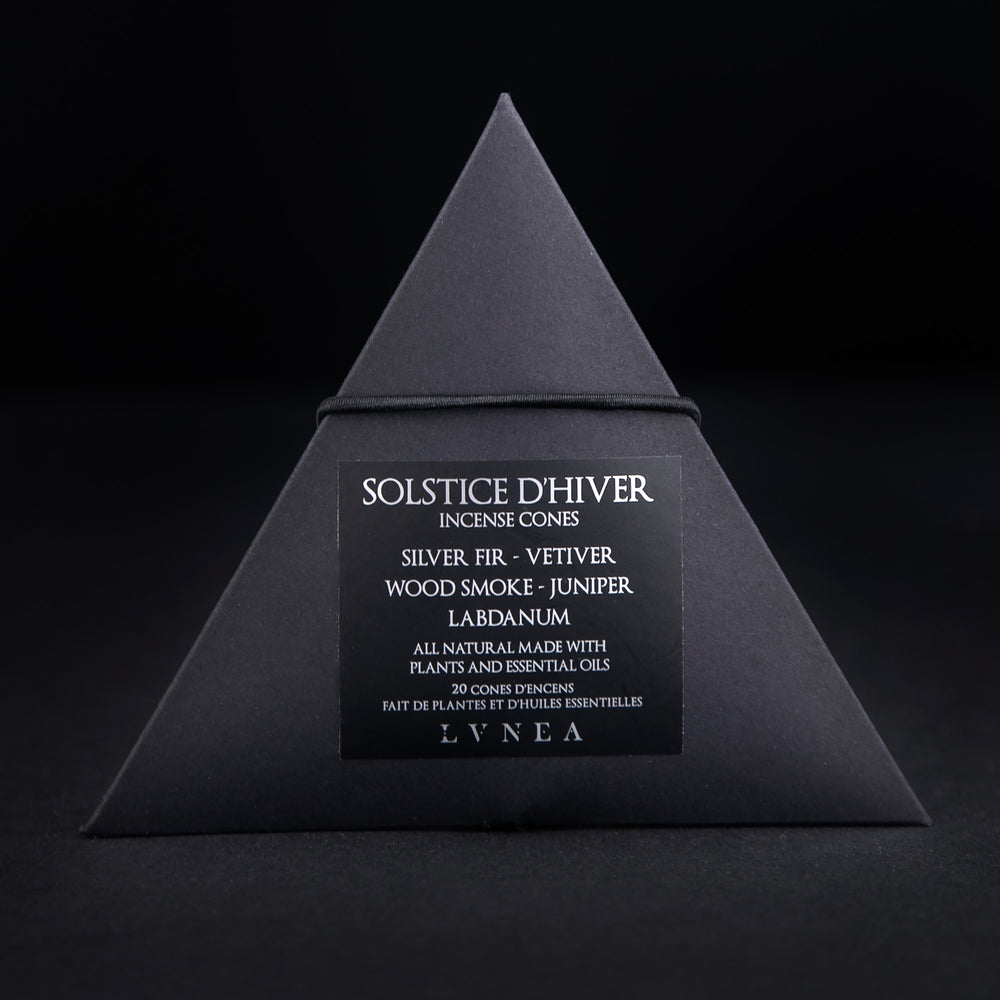 
                      
                        A closed black paper pyramid box of LVNEA's 'Solstice d'Hiver' incense. The black label on the box reads "Solstice d'Hiver Incense Cones: Silver Fir, Vetiver, Wood Smoke, Juniper, Labdanum" in silver foil
                      
                    