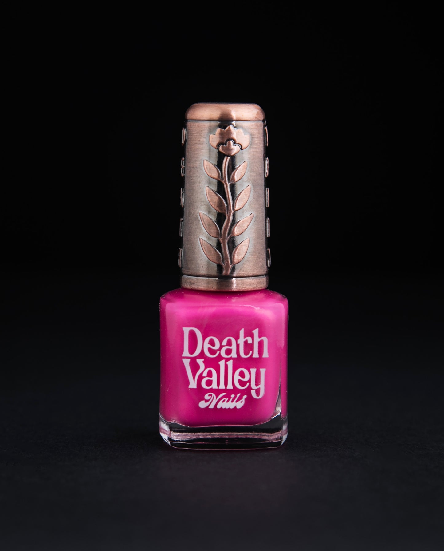 Bottle of "Sweet n Low" nailpolish on black background. The polish colour is a vibrant shimmery bubblegum pink.