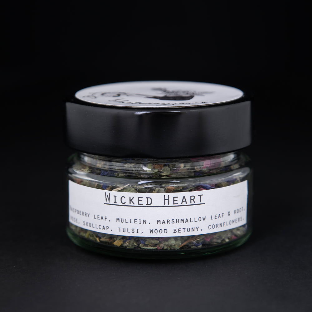 Clear glass jar of Blueberryjams' "Wicked Hearts" rolling blend against of black background