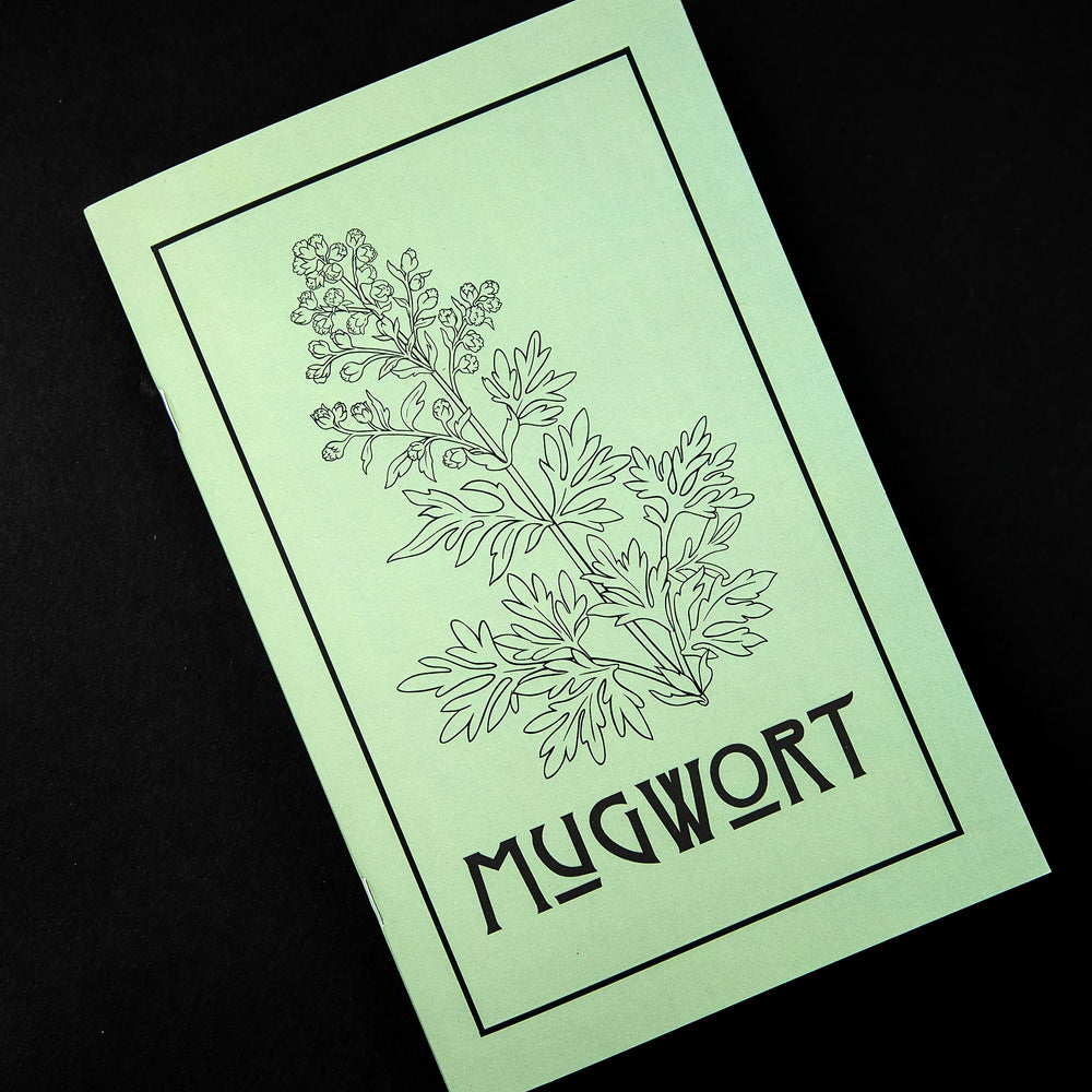 Herbal Revolution's zine about mugwort on black background. The cover is light green, reads "Mugwort" in bold lettering, and features a simple illustration of a mugwort plant.