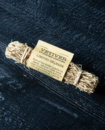 A bundle of dried vetiver roots on black wooden painted background.