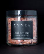 A clear 16 ounce jar filled with LVNEA's Fire Bathing bath salts on black background