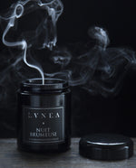 8 oz Nuit Brumeuse candle with lid removed. A plume of smoke is rising from the candle.