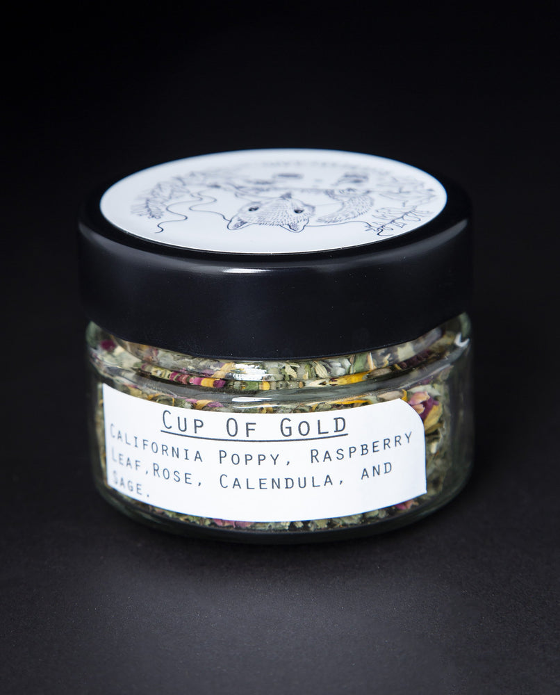 Clear glass jar with black lid containing blueberryjams' "Cup of Gold" rolling blend. English label is visible.