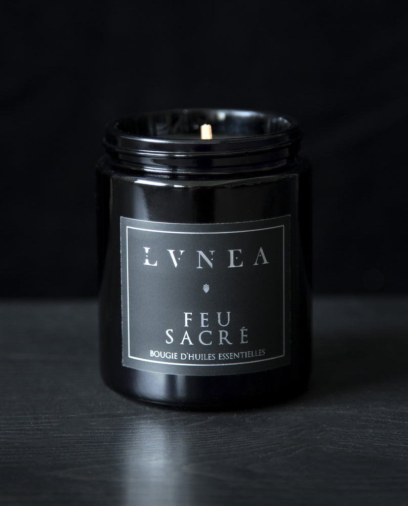 LVNEA’s Feu Sacré candle housed in a resealable 8 ounce black glass jar on a black background