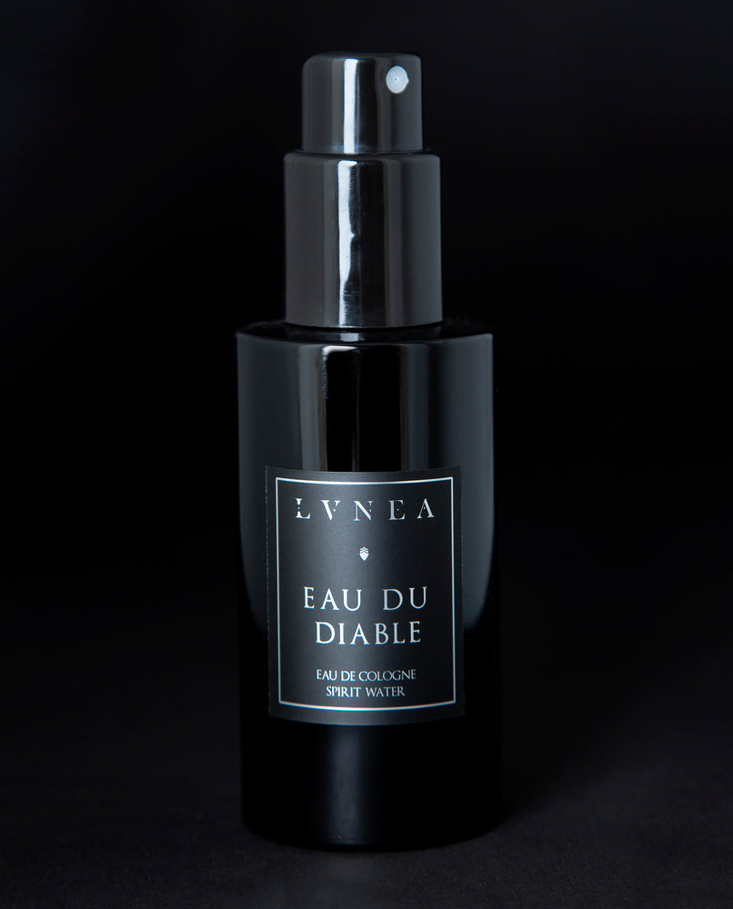 100ml black glass bottle of LVNEA’s Eau du Diable natural fragrance on black background